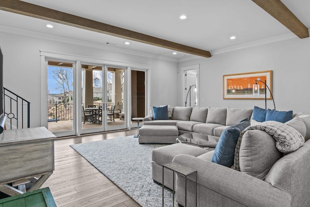 living room with beam ceiling, ornamental molding, light hardwood / wood-style floors, and french doors