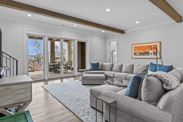 living room with beam ceiling, ornamental molding, light hardwood / wood-style floors, and french doors