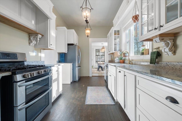 kitchen featuring dark wood-type flooring, stainless steel appliances, decorative light fixtures, and white cabinets