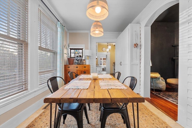 dining area featuring crown molding and light hardwood / wood-style flooring