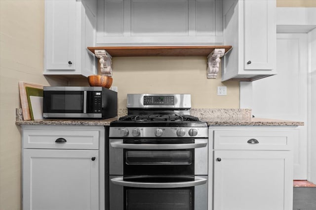 kitchen featuring white cabinetry, appliances with stainless steel finishes, and light stone counters