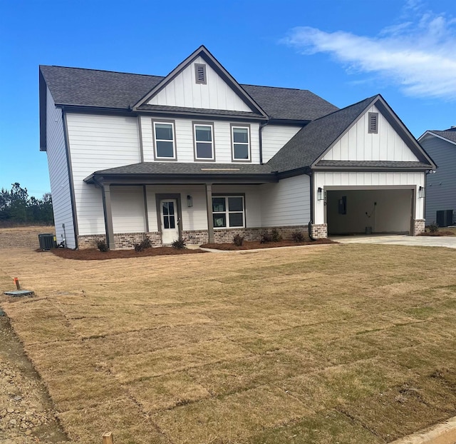 view of front of home featuring central AC, a garage, and a front yard