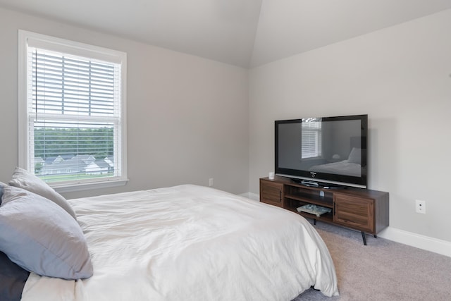 bedroom featuring lofted ceiling and light carpet