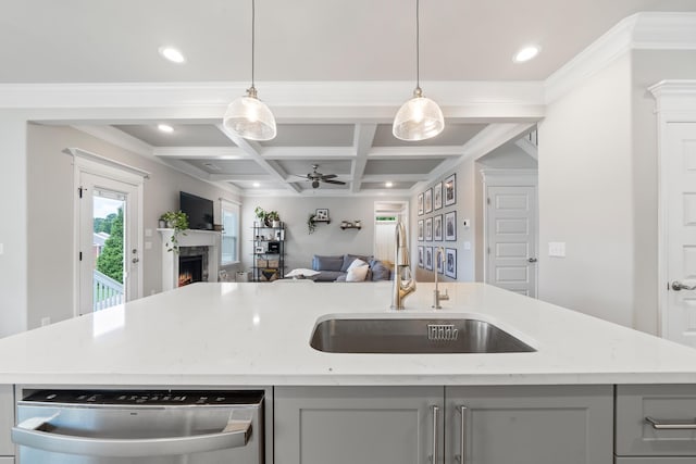 kitchen featuring light stone counters, stainless steel dishwasher, sink, and a kitchen island with sink