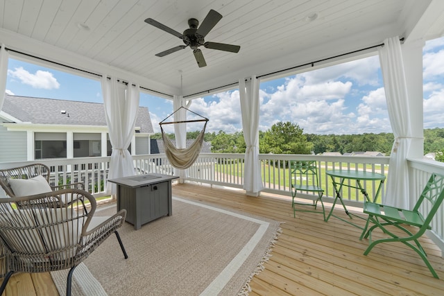 sunroom featuring ceiling fan, wooden ceiling, and a wealth of natural light