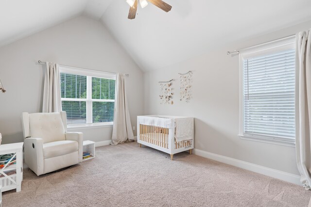 bedroom featuring a crib, lofted ceiling, carpet flooring, and ceiling fan