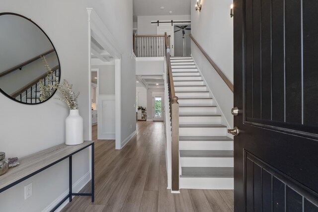 entrance foyer featuring a barn door, a high ceiling, and light wood-type flooring