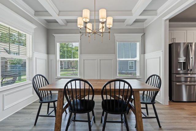 dining room featuring beamed ceiling, coffered ceiling, an inviting chandelier, and light hardwood / wood-style floors