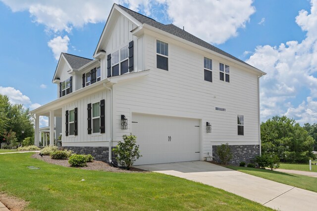 view of side of property with a garage and a lawn