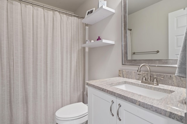 bathroom with vanity, curtained shower, and toilet