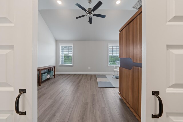 living room with vaulted ceiling, a healthy amount of sunlight, ceiling fan, and light hardwood / wood-style flooring