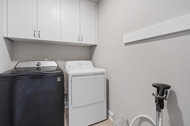 laundry area with cabinets and washing machine and clothes dryer