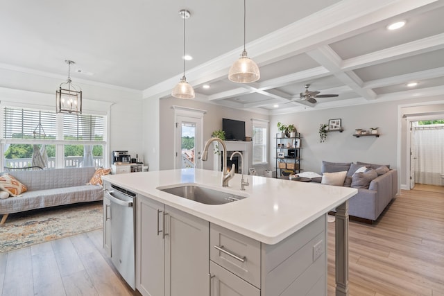 kitchen featuring sink, decorative light fixtures, a kitchen island with sink, dishwasher, and light hardwood / wood-style floors