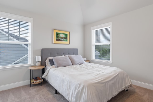 bedroom with lofted ceiling and light colored carpet