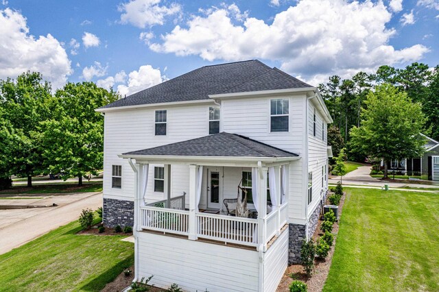 back of property featuring central AC unit, covered porch, and a lawn