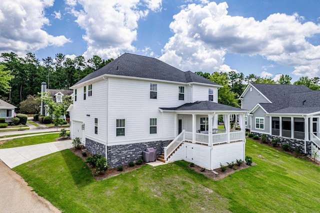 back of property with a garage, a yard, and covered porch