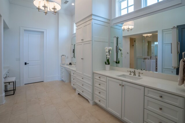 bathroom with vanity, a towering ceiling, and a chandelier