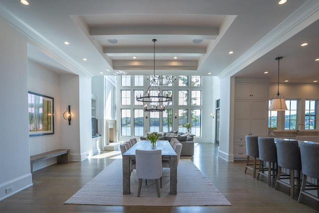 dining space with dark wood-type flooring, a towering ceiling, a chandelier, and built in features