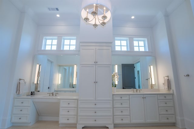 bathroom with a towering ceiling, vanity, and a wealth of natural light