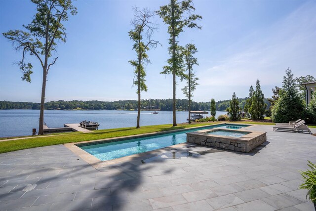 view of swimming pool with an in ground hot tub, a water view, and a patio area