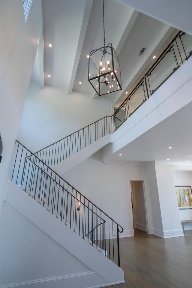 stairs featuring a high ceiling and hardwood / wood-style flooring