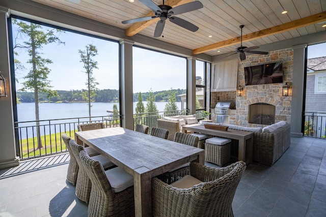 view of patio / terrace featuring ceiling fan and an outdoor stone fireplace