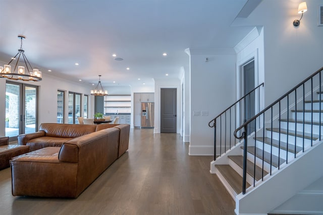 living room with an inviting chandelier, crown molding, french doors, and hardwood / wood-style flooring