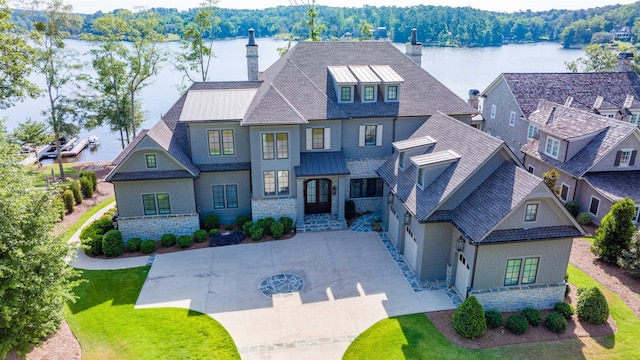 view of front of home with a water view and a front lawn