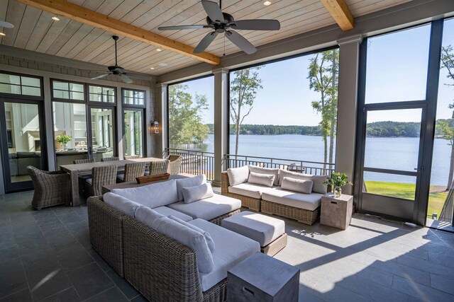 sunroom with ceiling fan, a water view, wooden ceiling, and beam ceiling