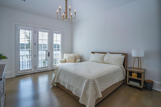 bedroom with an inviting chandelier, dark hardwood / wood-style floors, and access to outside