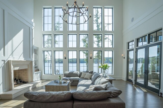 living room with hardwood / wood-style floors, a high end fireplace, french doors, and a healthy amount of sunlight