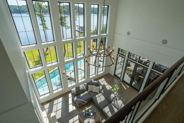 interior space featuring an inviting chandelier, a towering ceiling, plenty of natural light, and hardwood / wood-style flooring