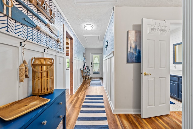 150 Possum Point Dr, Eatonton, GA 31024 - hallway with attic access, a textured ceiling, light wood-type flooring, and baseboards