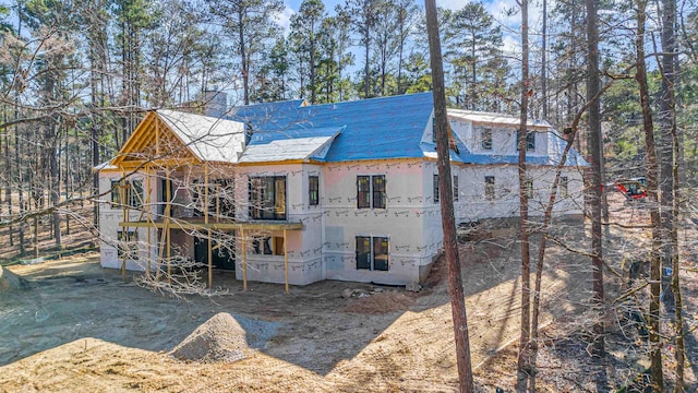 back of house with a chimney