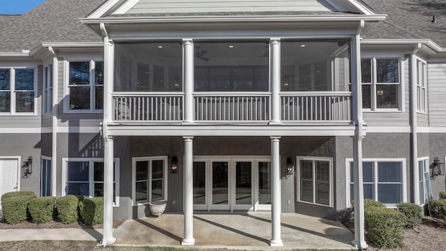 back of house with a sunroom, stucco siding, and a patio