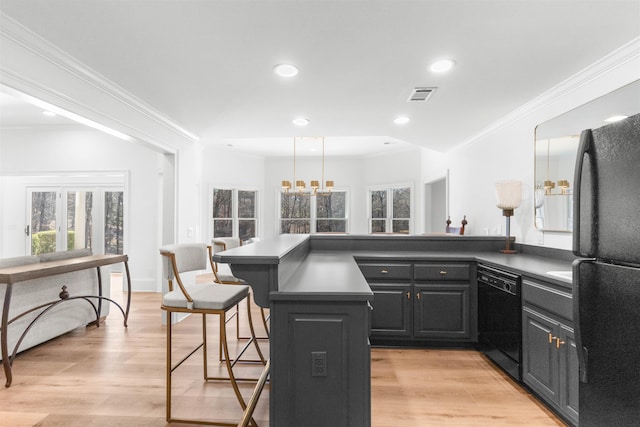 kitchen with crown molding, visible vents, black appliances, light wood-type flooring, and a kitchen bar