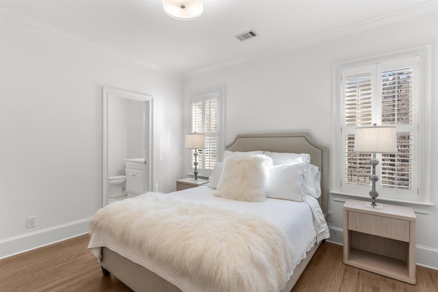 bedroom with visible vents, ensuite bathroom, ornamental molding, wood finished floors, and baseboards