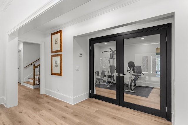 corridor featuring stairway, wood finished floors, crown molding, and french doors