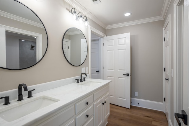 full bathroom with double vanity, wood finished floors, a sink, and crown molding
