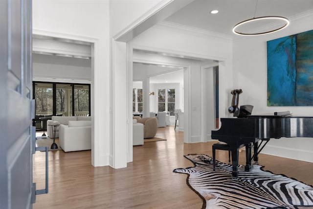 foyer entrance with ornamental molding, baseboards, and wood finished floors