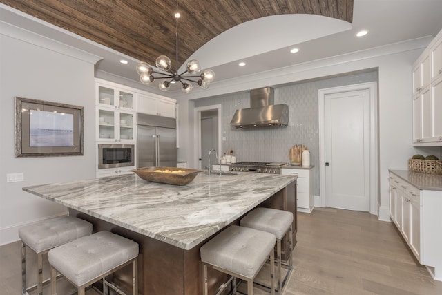 1010 Thorton Crk, Greensboro, GA 30642 - kitchen featuring wall chimney exhaust hood, built in appliances, vaulted ceiling, a sink, and wood finished floors