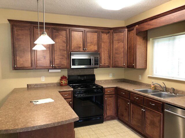 104 Wesley Ln, Eatonton, GA 31024 - kitchen featuring appliances with stainless steel finishes, a sink, decorative light fixtures, dark brown cabinets, and a textured ceiling