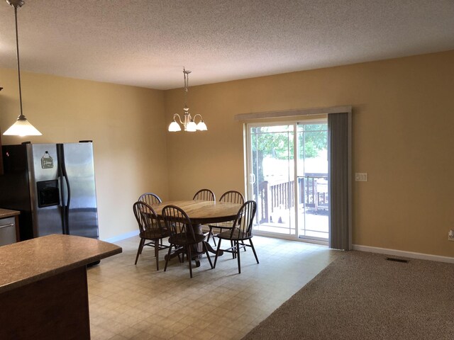 104 Wesley Ln, Eatonton, GA 31024 - dining room with a chandelier, a textured ceiling, baseboards, and light floors