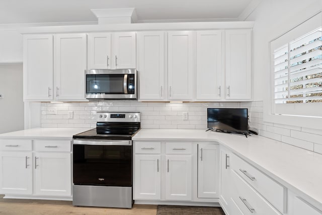 kitchen with stainless steel appliances, tasteful backsplash, light countertops, and white cabinetry