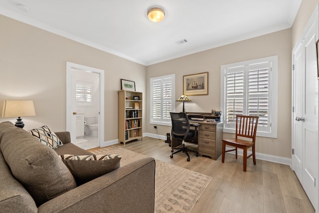 office with visible vents, baseboards, crown molding, and light wood-style flooring
