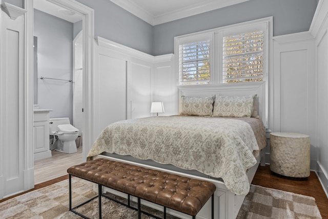 bedroom with crown molding, ensuite bath, and hardwood / wood-style floors