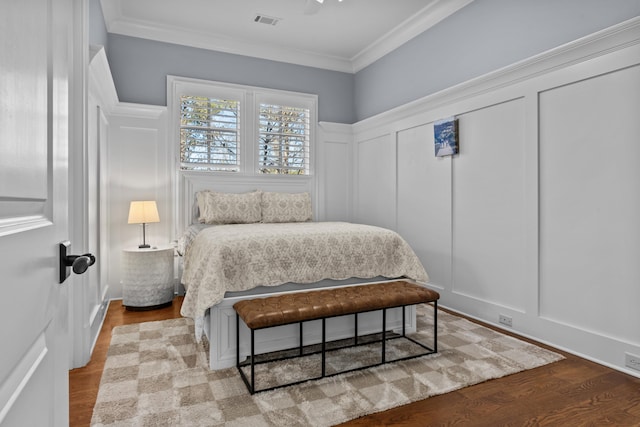 1030 Ridge Grove Ct, Greensboro, GA 30642 - bedroom with a decorative wall, wood finished floors, visible vents, crown molding, and wainscoting