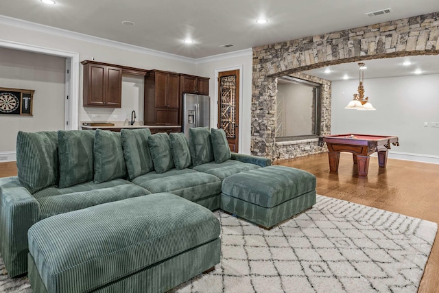 living room with billiards, sink, light hardwood / wood-style flooring, and ornamental molding