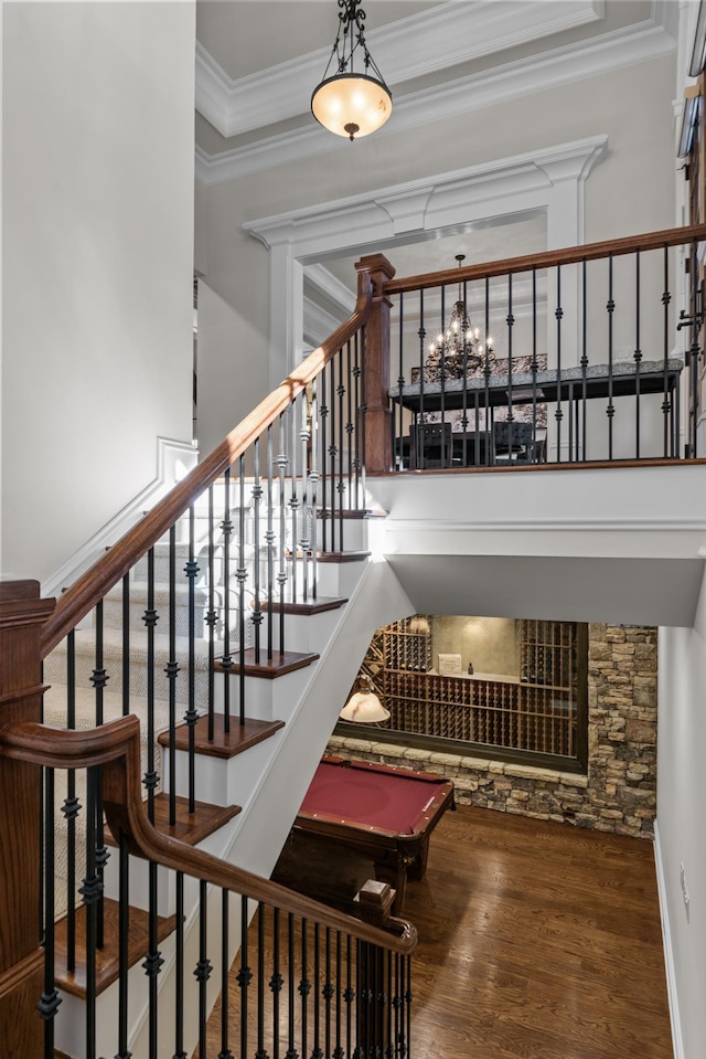 stairway featuring pool table, ornamental molding, and hardwood / wood-style floors