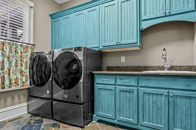 1030 Ridge Grove Ct, Greensboro, GA 30642 - washroom featuring a sink, cabinet space, stone finish floor, visible vents, and washing machine and dryer